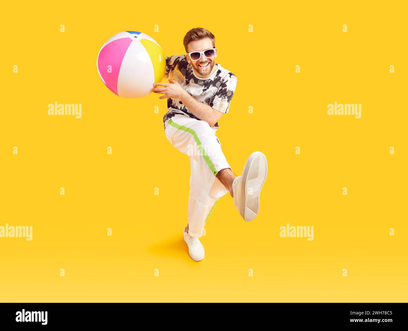 Gars heureux dans des lunettes de soleil s'amusant avec ballon de mer gonflable Banque D'Images