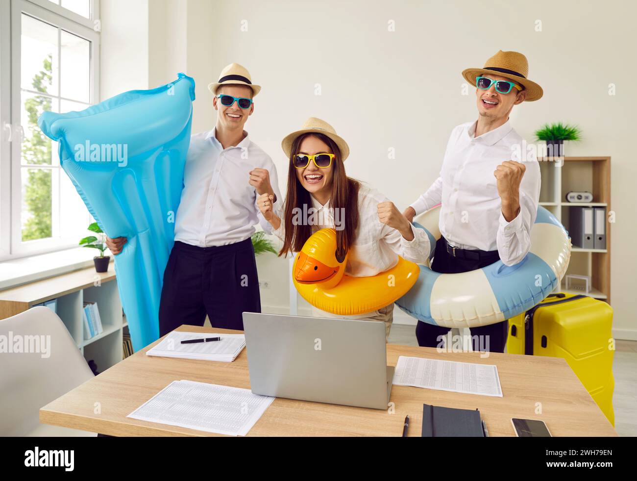 Joyeuse équipe de travailleurs de bureau prêts à partir en vacances d'été s'amuser au bureau. Banque D'Images