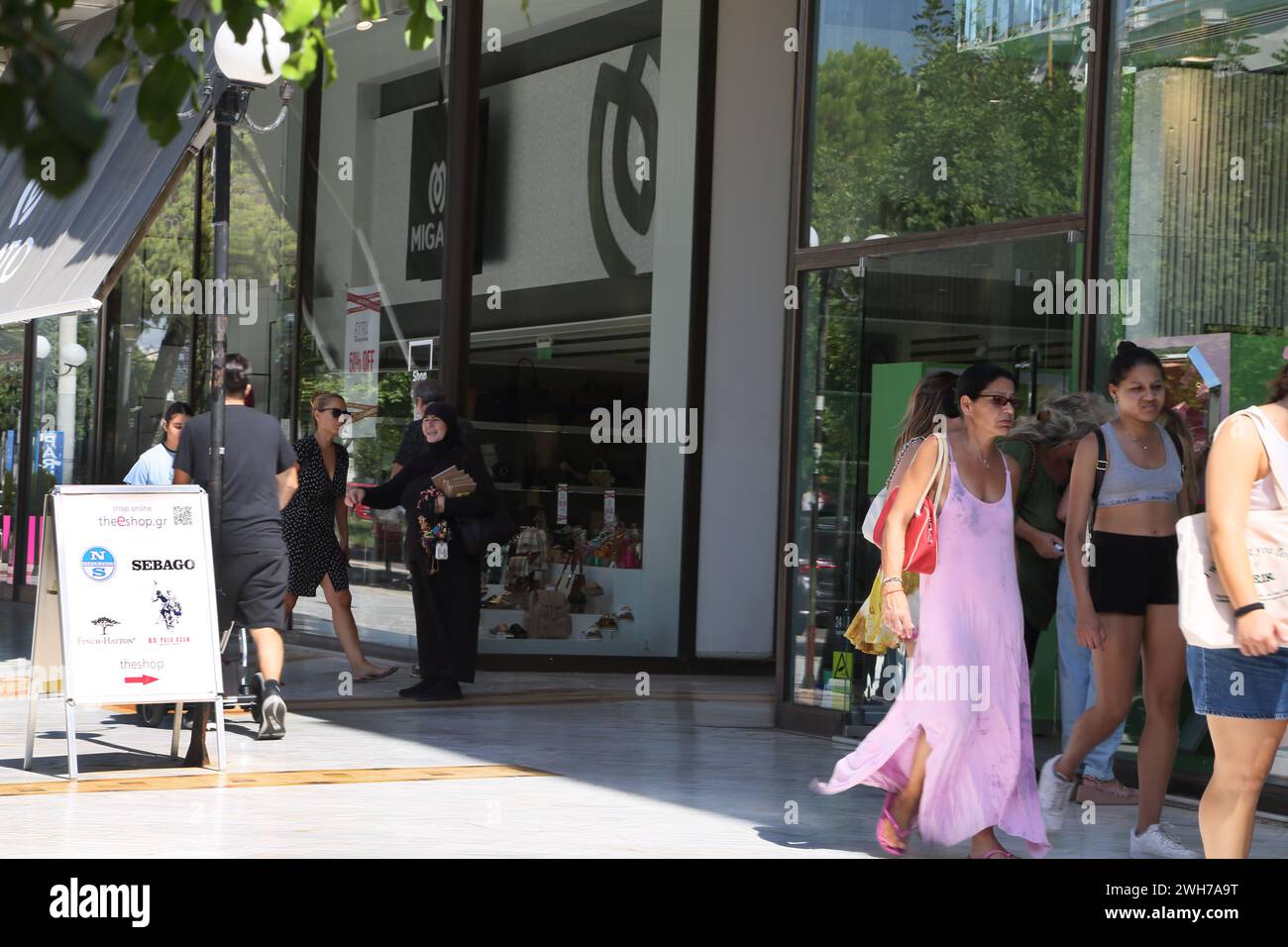 Femme vendant des bibelots et bracelets debout en dehors des magasins Athens Attica Grèce Banque D'Images