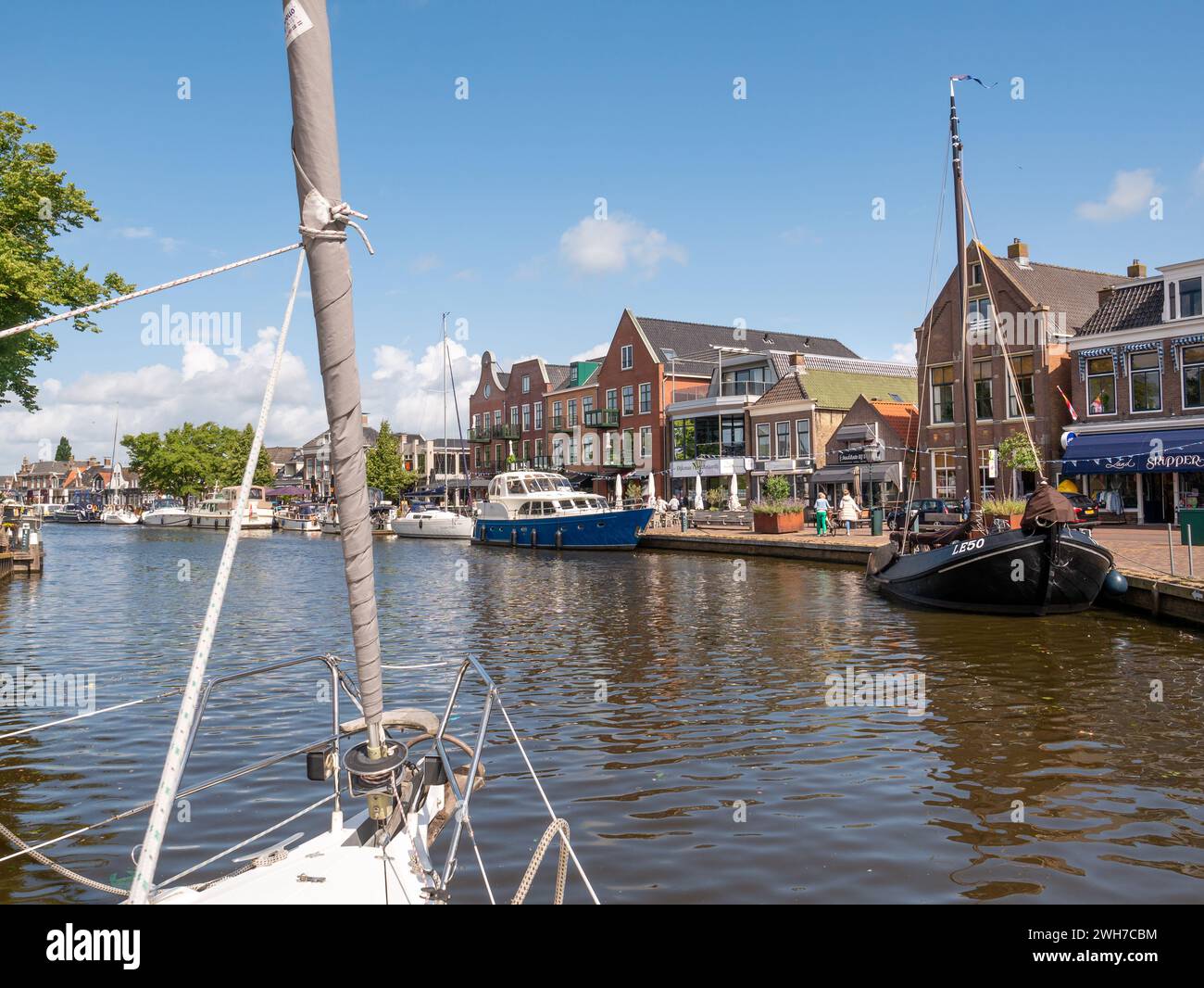 Voilier à moteur dans le canal Het Dok près du quai Kortestreek dans la vieille ville de Lemmer, Frise, pays-Bas Banque D'Images