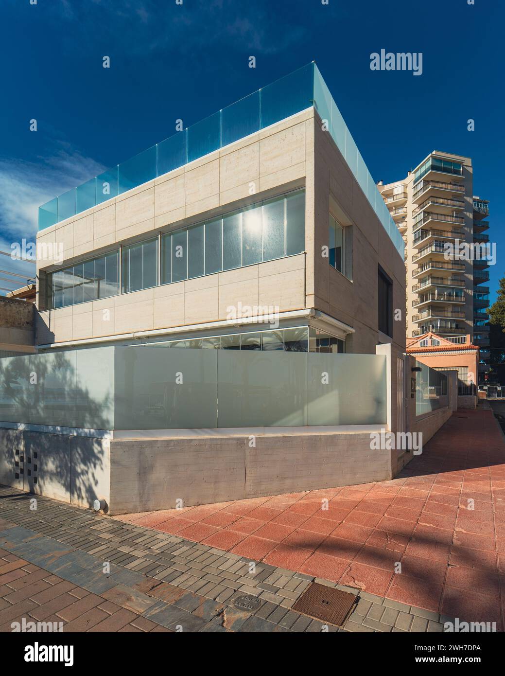 Une maison moderne avec des balustrades en verre blanc élégant et des panneaux de verre d'intimité Banque D'Images