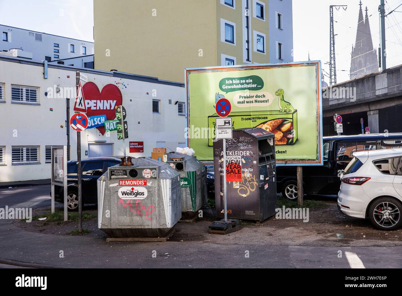 Récipient en verre usagé, récipient de vêtements usagé et panneau d'affichage sur la rue am Salzmagzin dans le quartier Eigelstein, en arrière-plan la cathédrale, Co Banque D'Images