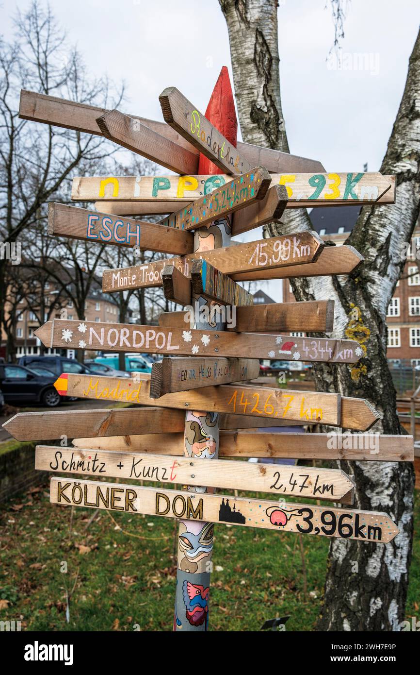 Un panneau indiquant la distance se trouve dans le jardin scolaire de l'école Theodor-Heuss dans le quartier Suelz, Cologne, Allemagne. ein Wegweise Banque D'Images