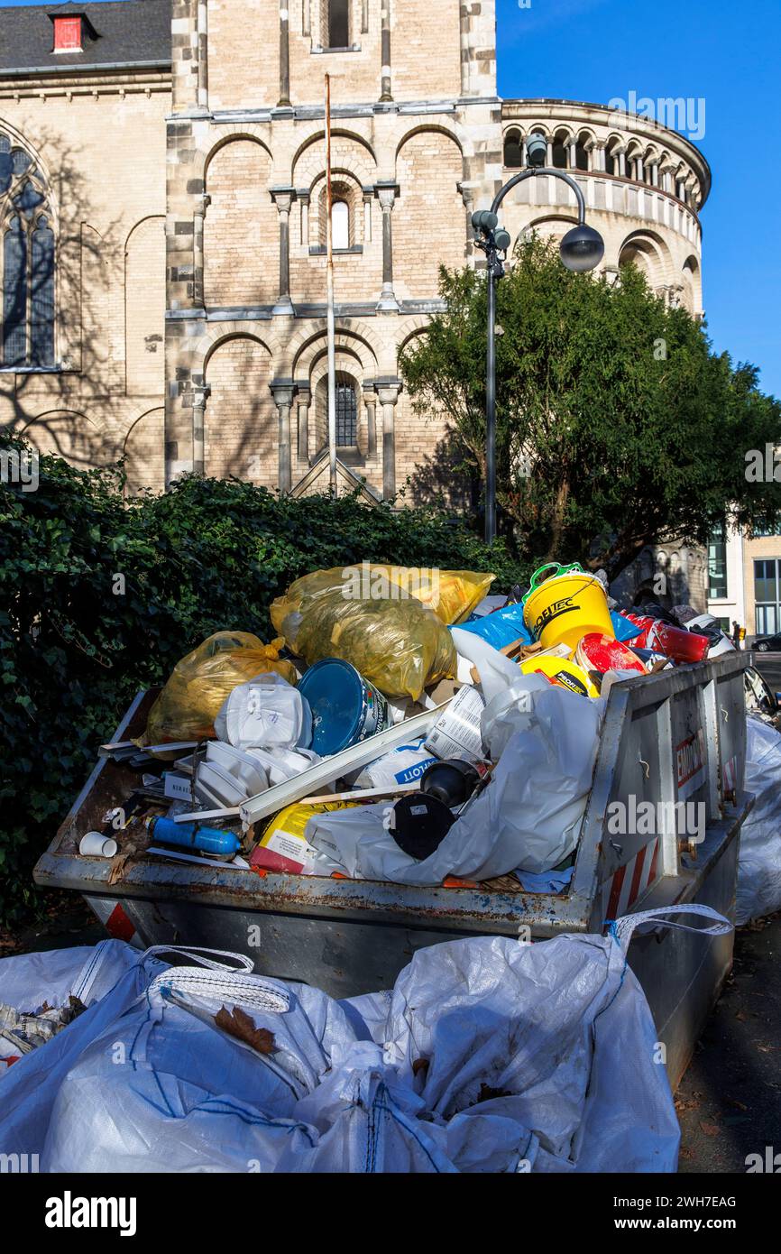 Un conteneur et des sacs lourds de déchets de construction se dressent devant le besoin Église Gereon, Cologne, Allemagne. ein Container und Schwerlastsaeck Banque D'Images