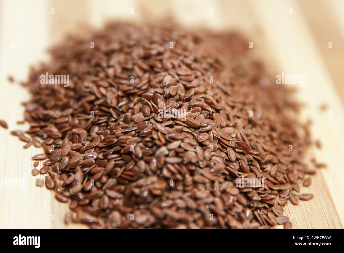 Les graines de lin brutes reposent sur une surface en bois dans la cuisine, préparées pour la cuisson. Vue de dessus. Effectuer la mise au point au centre des grains Banque D'Images