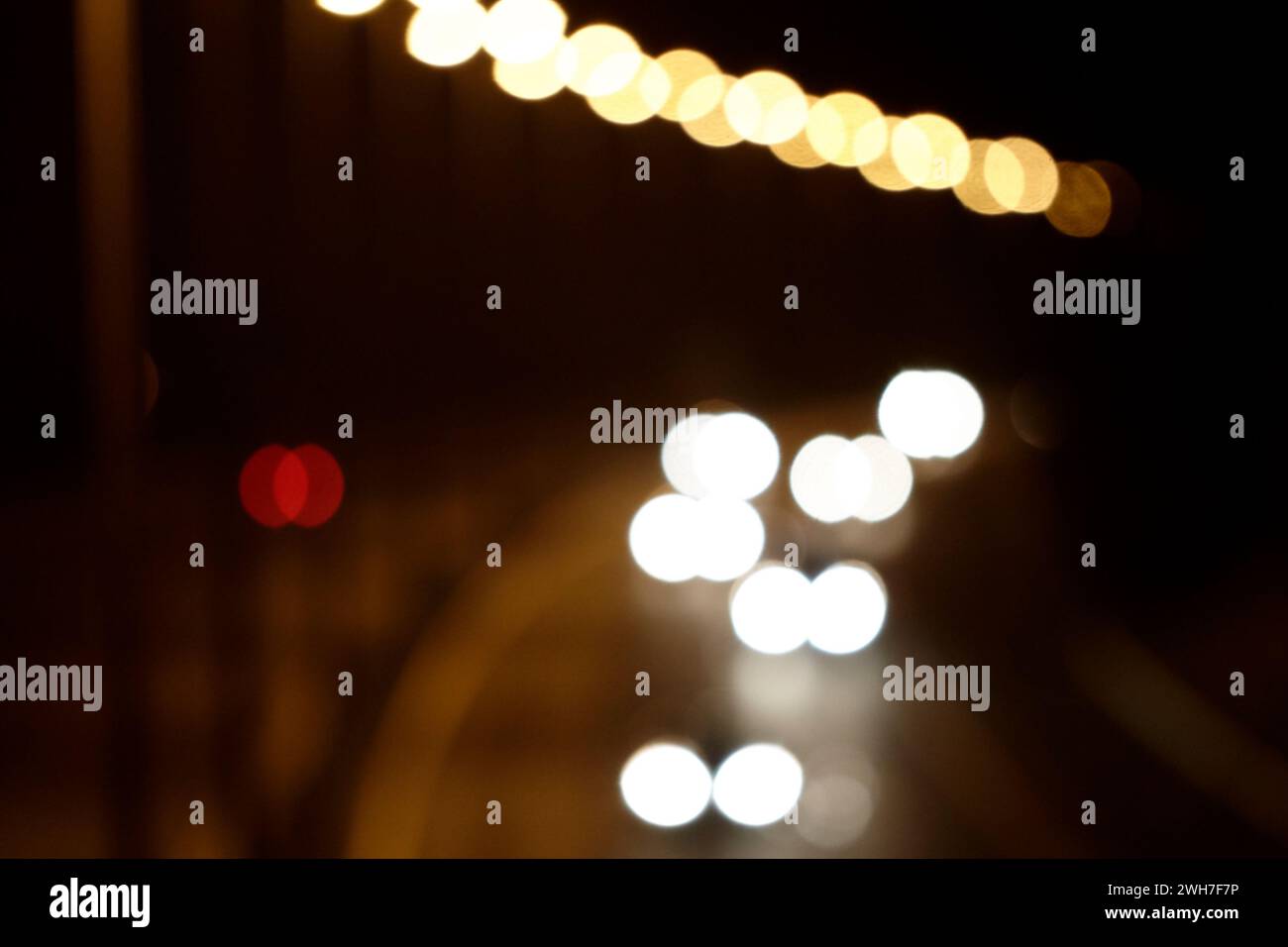 les phares de voiture circulant le long de l'autoroute éclairée la nuit ont rendu flou l'image conceptuelle floue Banque D'Images