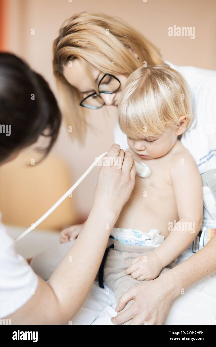 Petit enfant étant examiné pour le souffle cardiaque par l'examen d'échographie cardiaque par cardiologue dans le cadre du contrôle médical régulier au pédiatre Banque D'Images