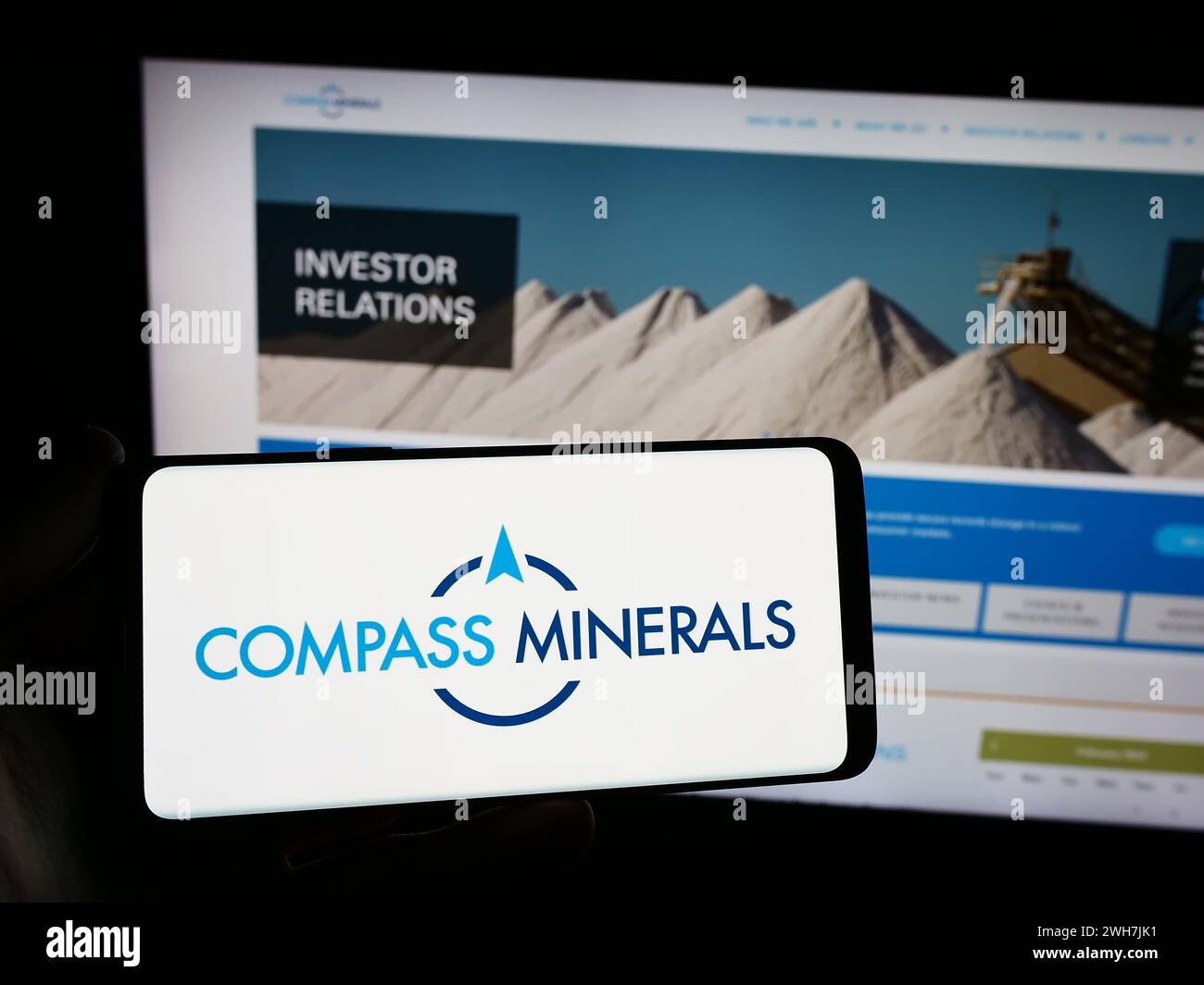 Personne tenant un téléphone portable avec le logo de la société minière américaine Compass Minerals International Inc devant la page Web de l'entreprise. Concentrez-vous sur l'affichage du téléphone. Banque D'Images