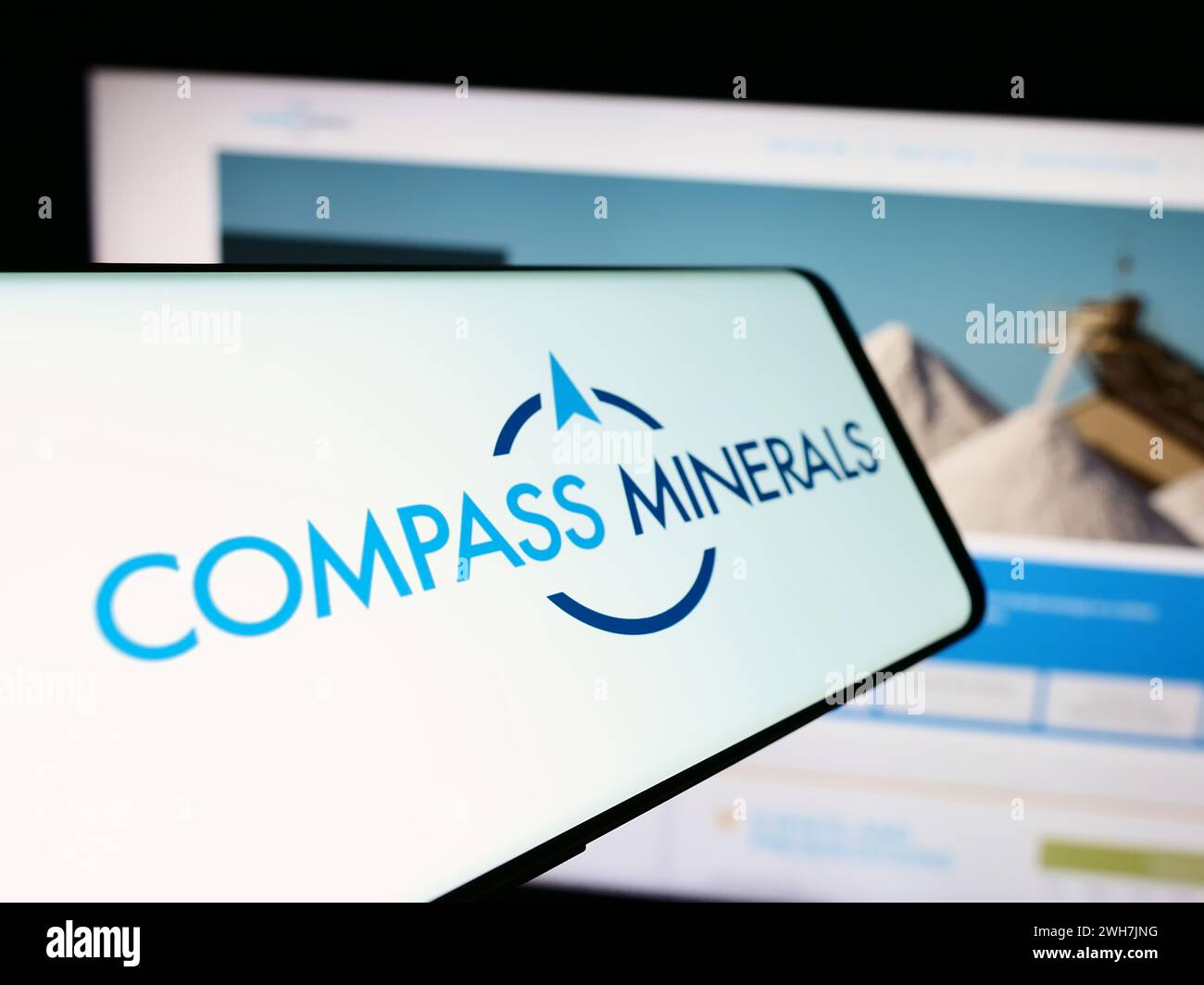 Téléphone portable avec le logo de la société minière américaine Compass Minerals International Inc en face du site Web. Mettez l'accent sur le centre-gauche de l'écran du téléphone. Banque D'Images
