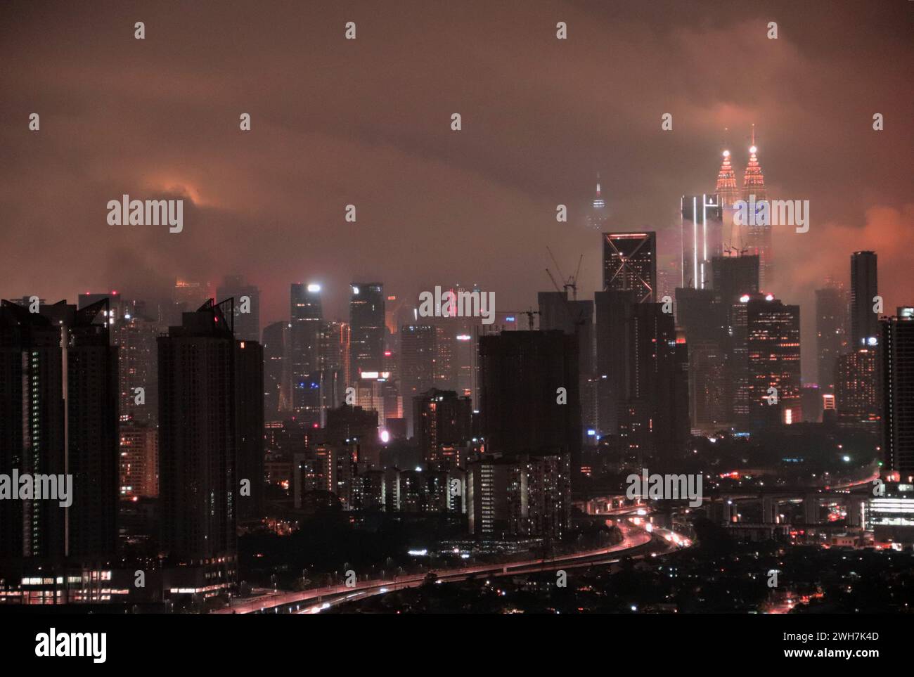 L'horizon de Kuala Lumpur avec les tours jumelles Petronas illuminées pour le nouvel an chinois et entourées de nuages bas KL, Malaisie. Banque D'Images