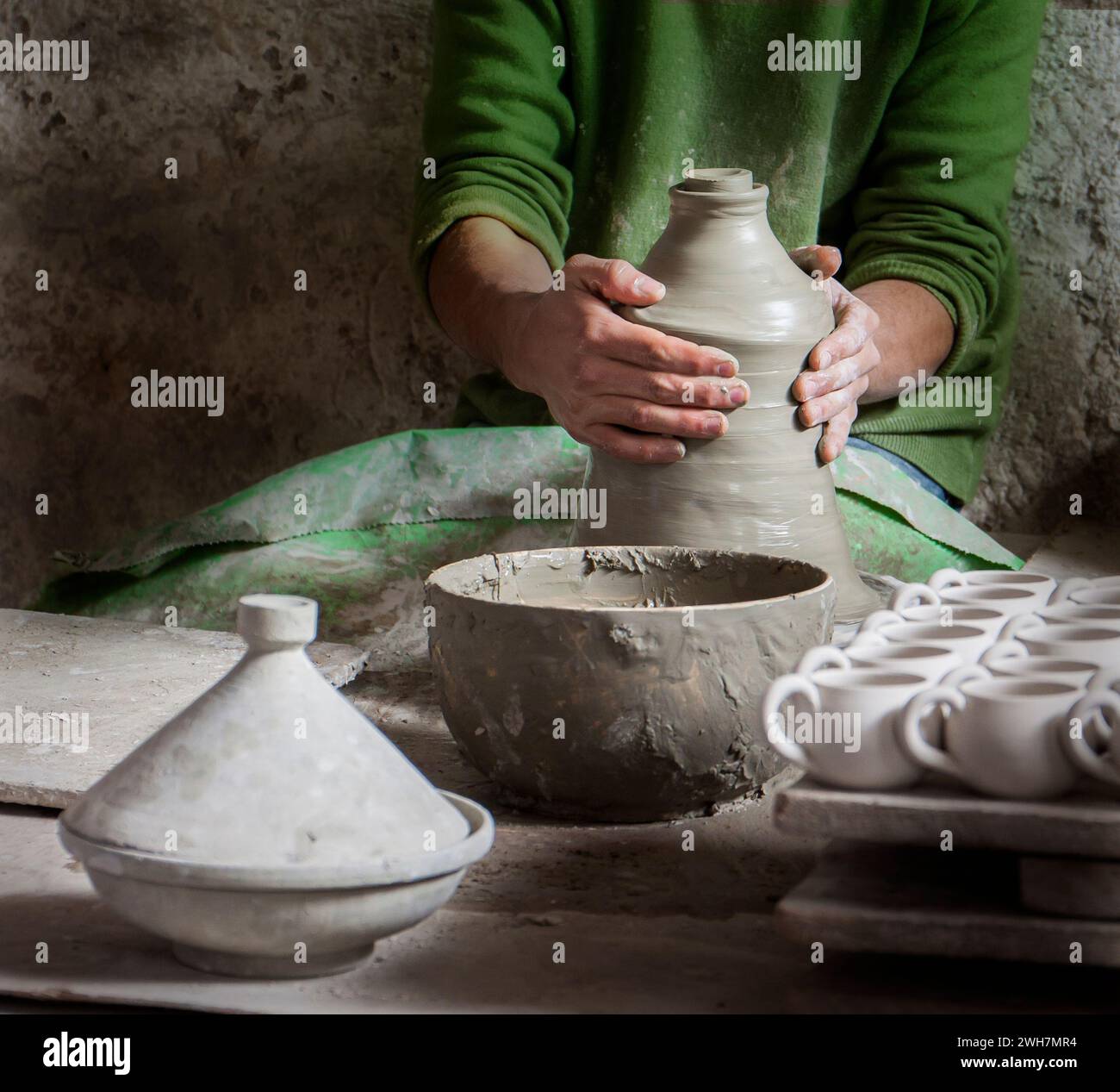 Main de potier marocain jetant un pot en argile tagine à vendre sur le marché Banque D'Images