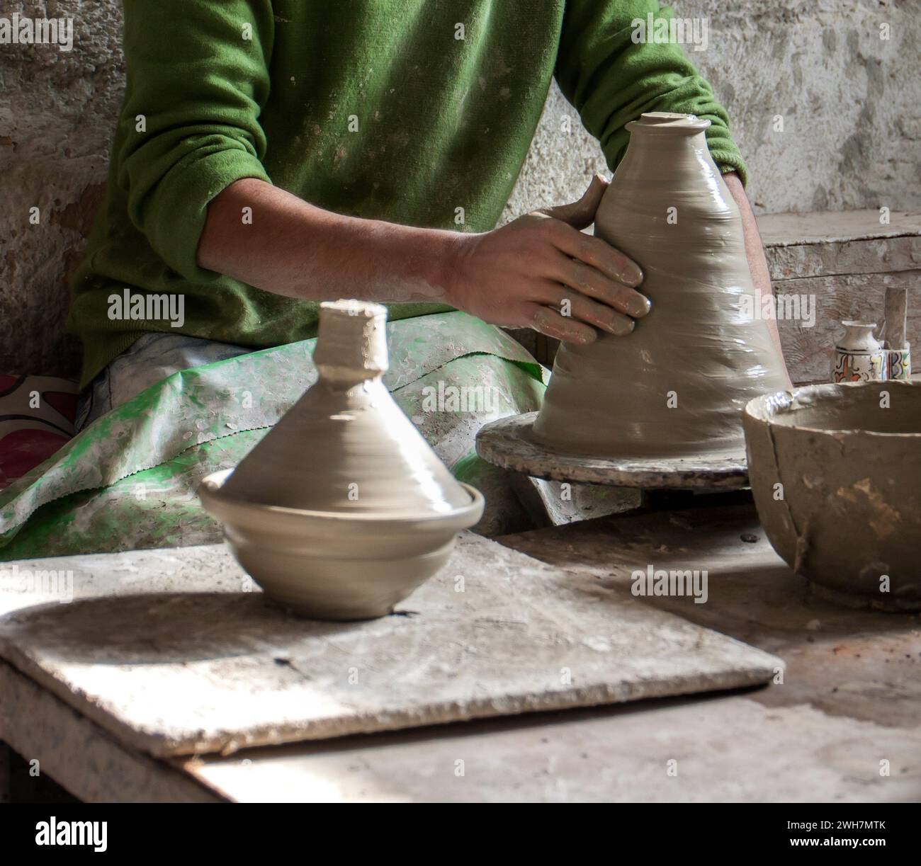 Main de potier marocain jetant un pot en argile tagine à vendre sur le marché Banque D'Images