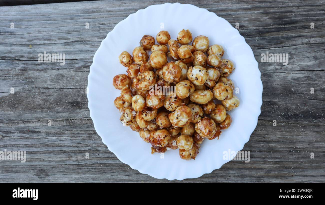 Délicieux snack maison noix de renard caramalisées ou snack Makhana. Plat croustillant au caramel aux graines de lotus soufflé fait maison Banque D'Images