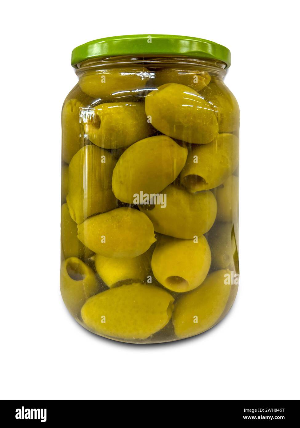 Olives vertes dénoyautées en saumure dans un bocal en verre isolé sur blanc avec chemin de détourage inclus Banque D'Images