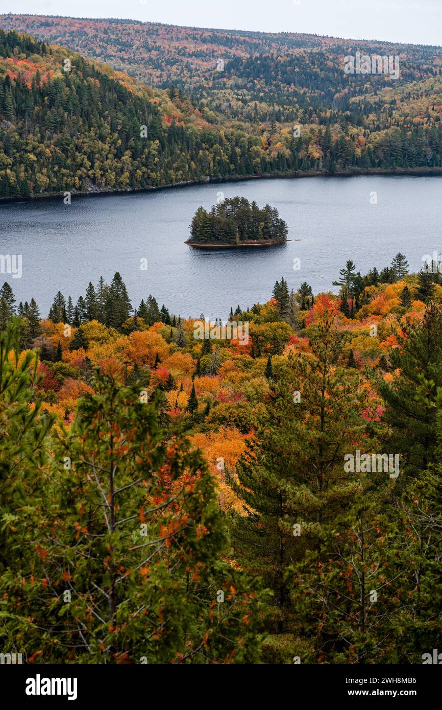 Pine Island au milieu du lac Wapizagonke entouré de collines boisées colorées en automne, Parc national de la Mauricie, Québec, Canada Banque D'Images