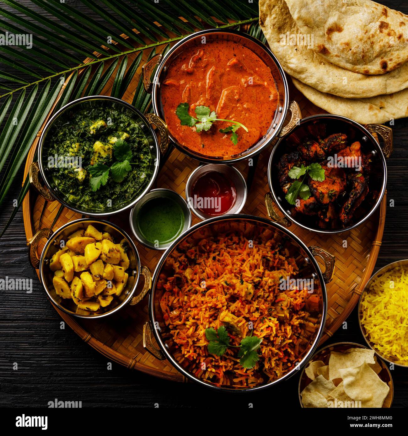 Nourriture indienne poulet au beurre au curry, Palak Paneer, Chiken Tikka, Biryani, curry de légumes, Papad, Dal, Palak Sabji, Jira Alu, riz au safran sur noir b Banque D'Images