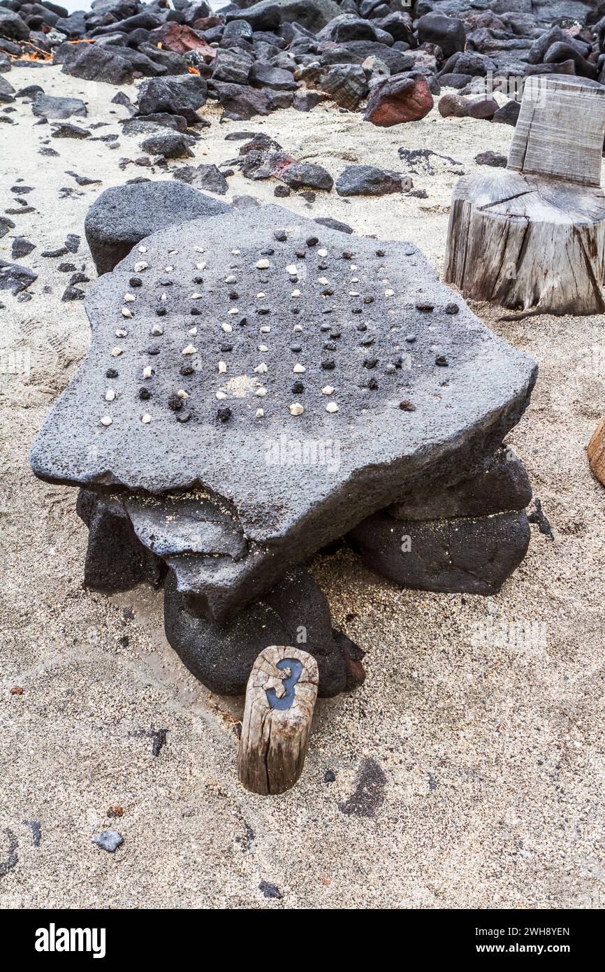 Jeu de stratégie hawaïen de Konane joué avec des cailloux sur une surface de pierre de lave, au pu'uhonua o Honaunau National Historical Park, Hawaï. Banque D'Images
