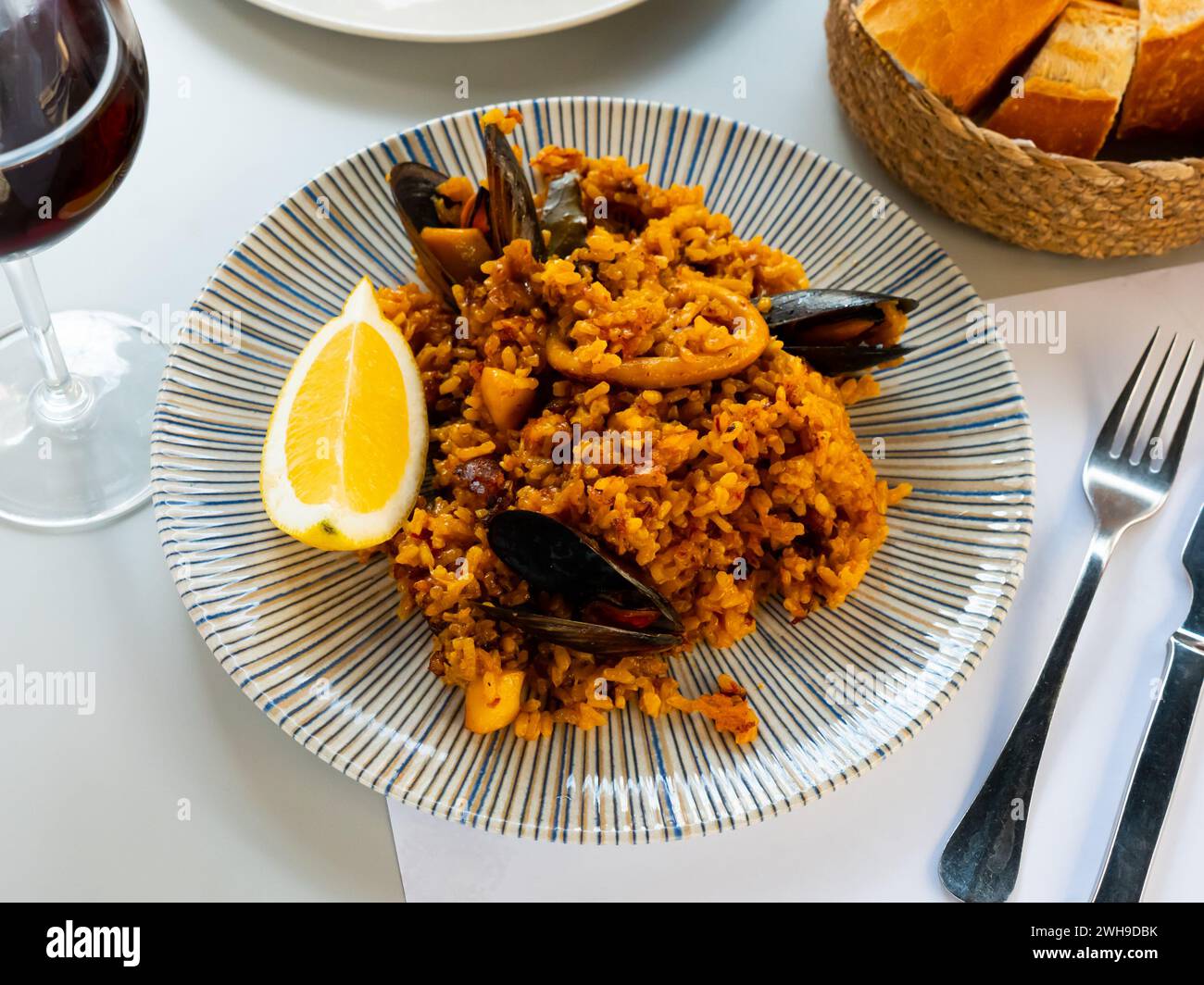 Paella de fruits de mer racée avec moules, rondelles de calmar et citron Banque D'Images