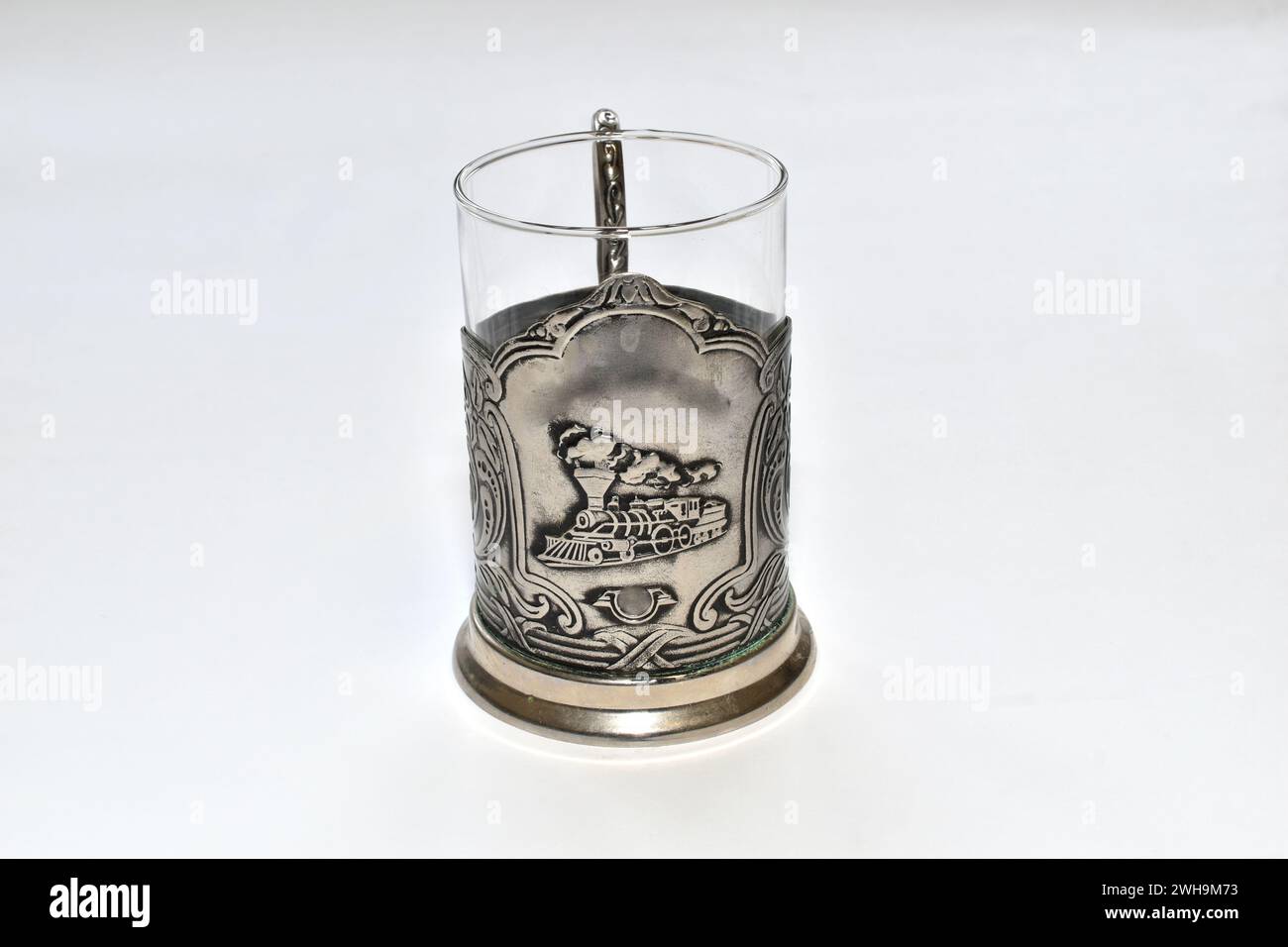 Support en verre pour un verre de thé chaud en métal avec l'image d'une locomotive à vapeur. Banque D'Images