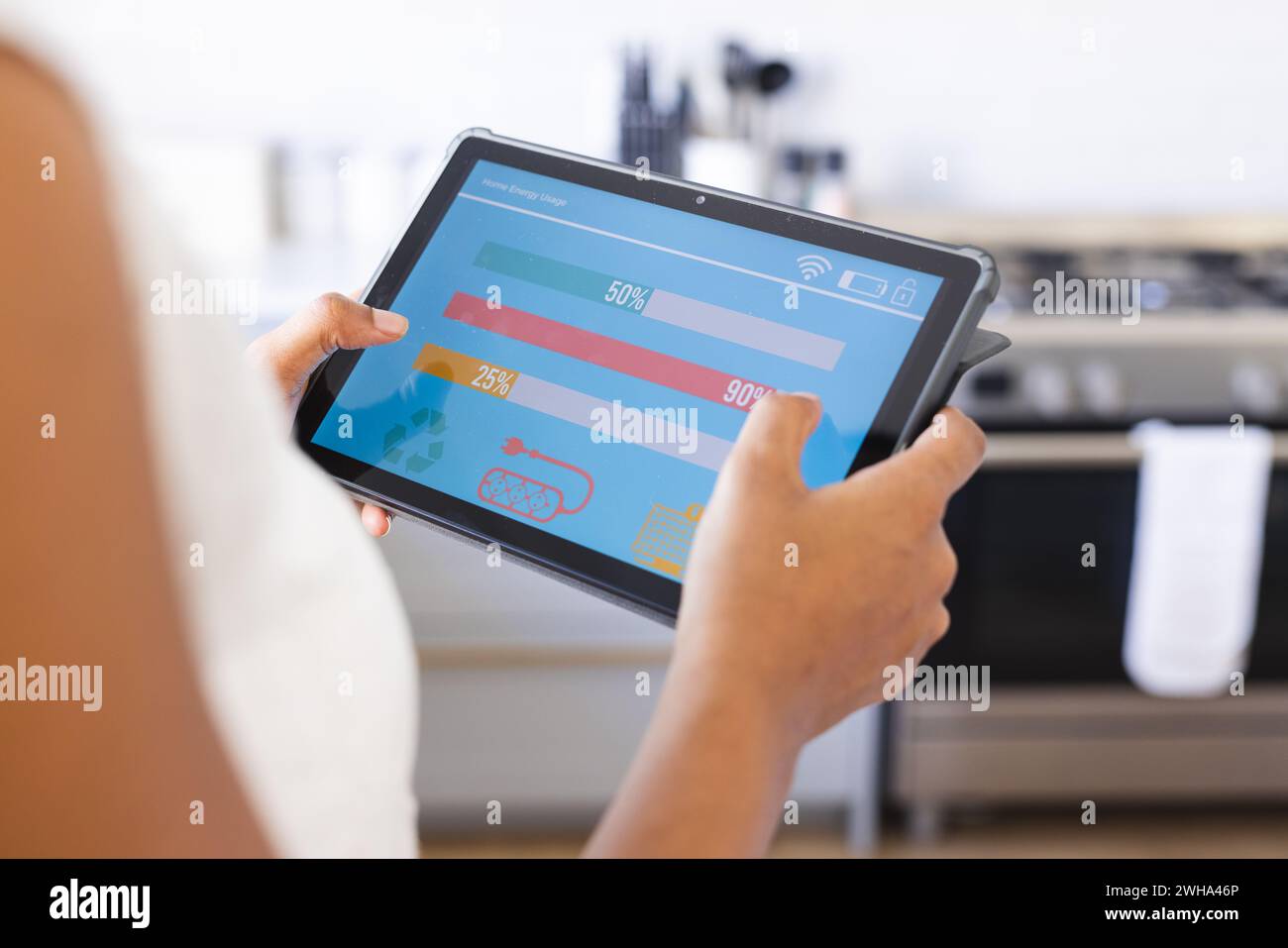 Une personne analyse les données sur une application de maison intelligente sur sa tablette dans le confort de son salon Banque D'Images