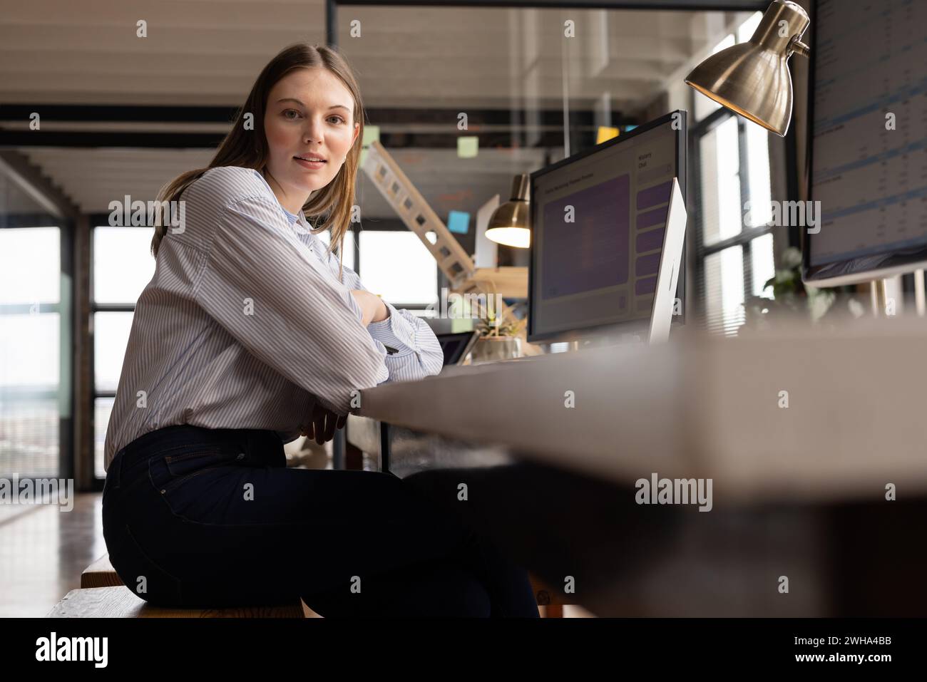 Jeune femme caucasienne pose dans un bureau d'affaires moderne et décontracté Banque D'Images