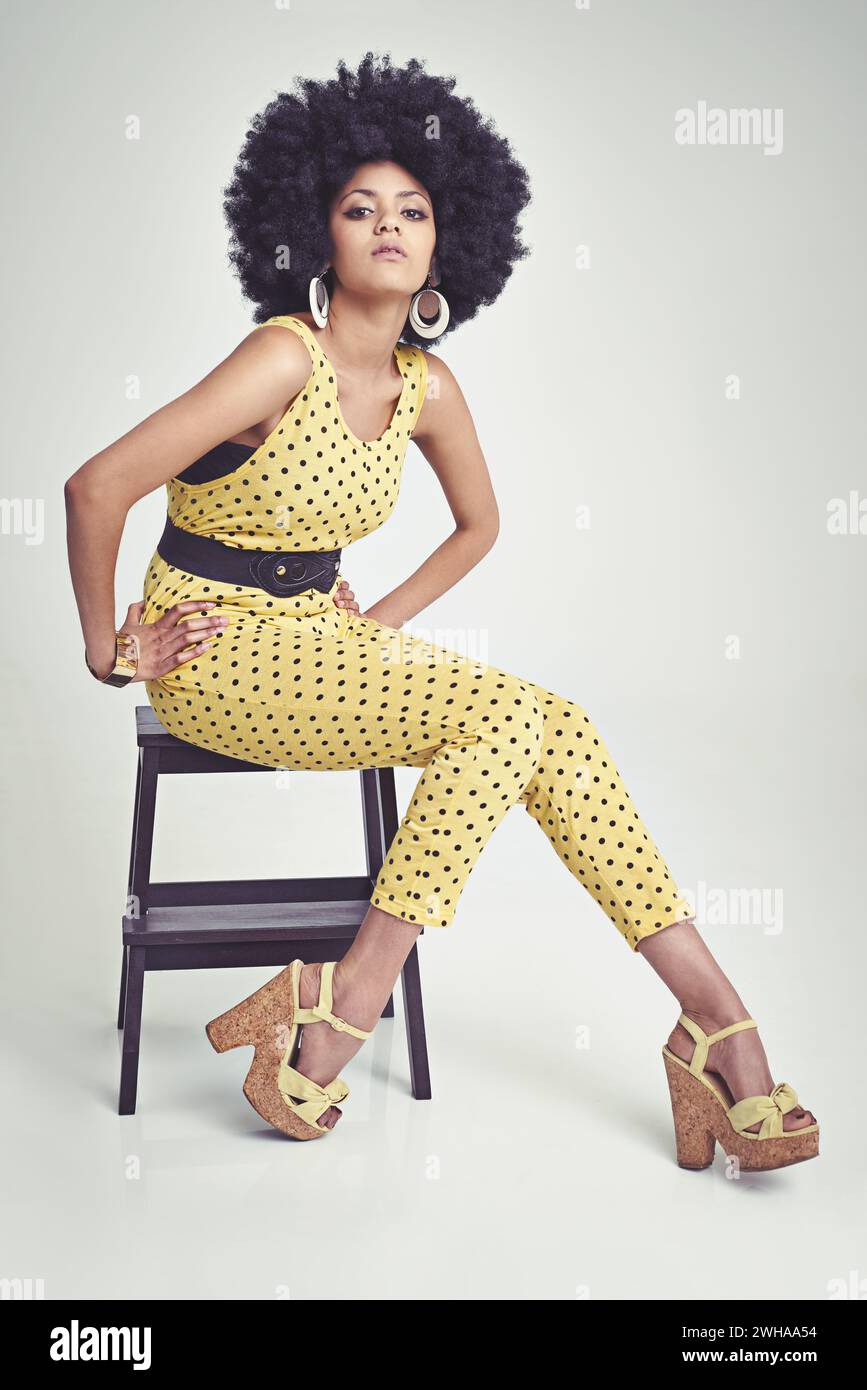 Fille africaine, portrait et mode en studio, vintage et main sur la taille, unique et points dans les vêtements. Rétro, afro et personne avec cheveux, modèle et Banque D'Images