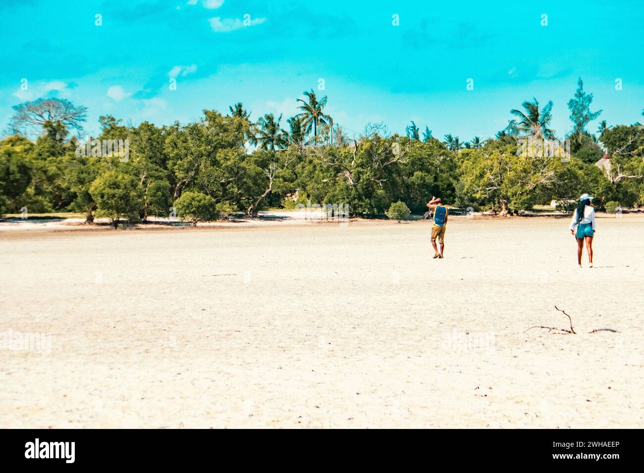 Un homme et une femme marchant sur la plage de sable de Mida Creek pendant la marée basse à Watamu, Malindi, Kenya Banque D'Images