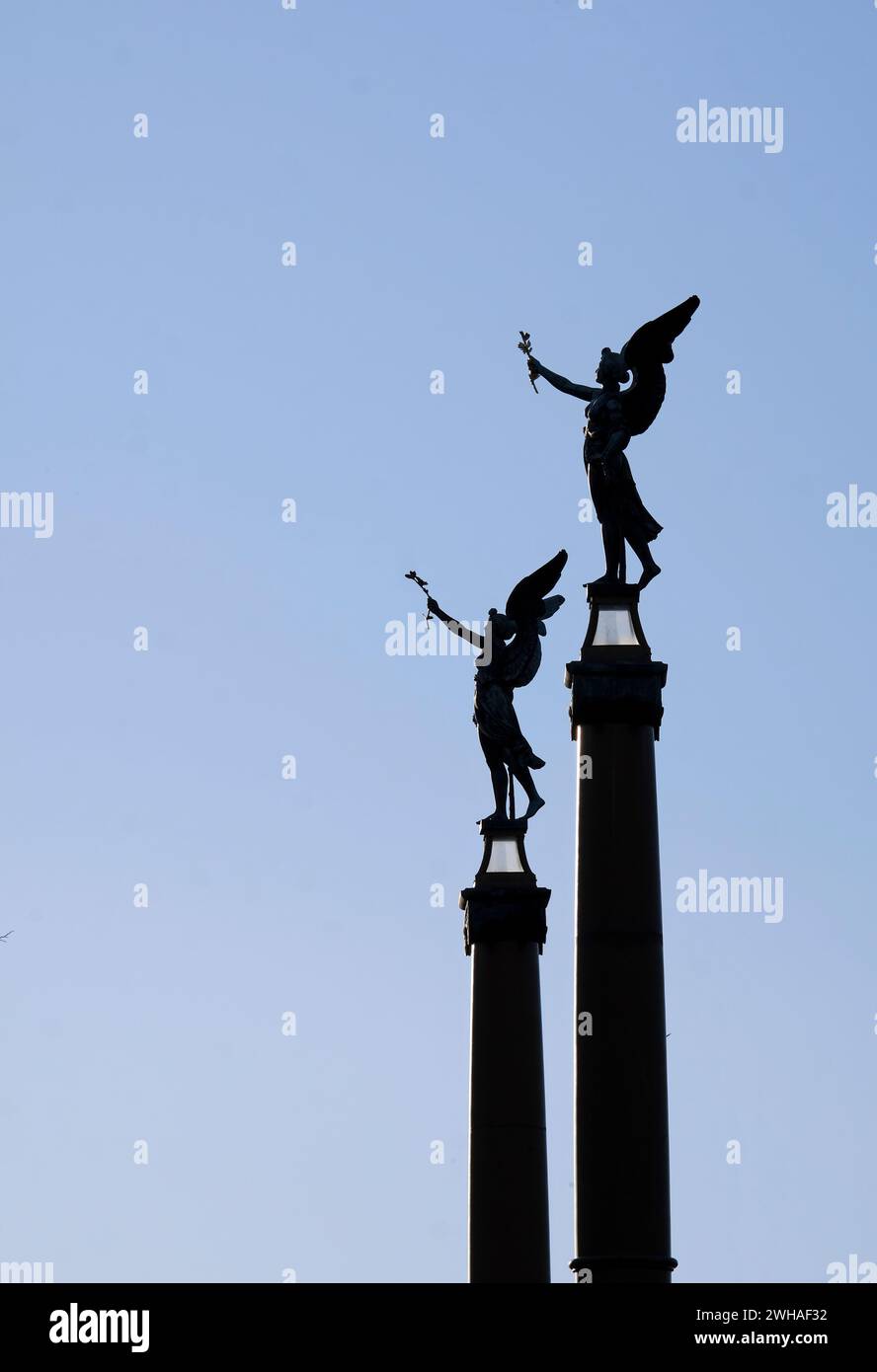 Deux statues d'ange avec des ailes contre le ciel bleu du soir Banque D'Images