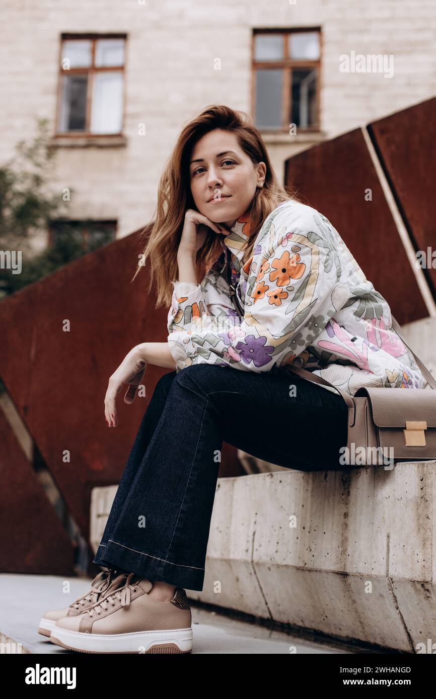 Portrait de femme en vêtements décontractés assis sur les marches Banque D'Images