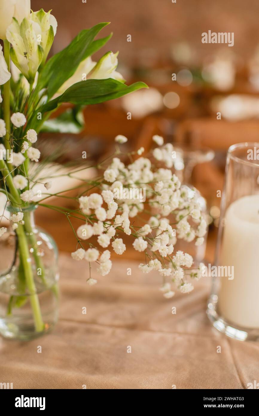 Gros plan des fleurs de souffle de bébé dans un vase en verre sur une table en bois Banque D'Images