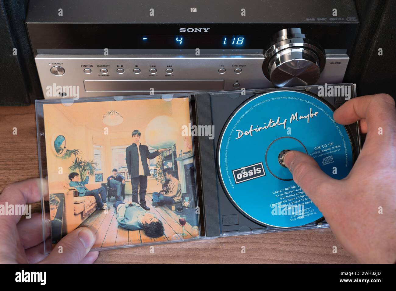 Defined Maybe a été publié en août 1994 par Oasis. C'est le premier album le plus vendu de tous les temps (à l'époque). Retirez manuellement le CD du boîtier Banque D'Images