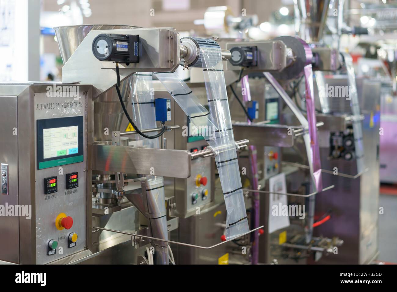 Une machine d'emballage automatique avancée fonctionne avec précision, avec un rouleau de film et un panneau de commande à écran tactile, essentiels pour la haute vitesse moderne Banque D'Images