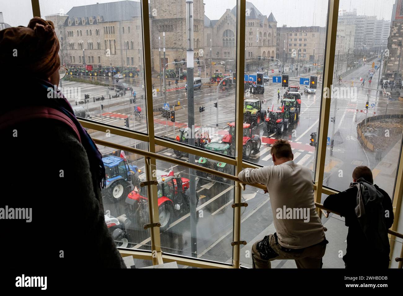 Poznan, Pologne, 9 février 2024. Les gens regardent des agriculteurs de la région de la Grande Pologne, dans l'ouest de la Pologne, monter leurs tracteurs alors qu'ils bloquent la route Aleja Niepodleglosci dans le centre de Poznań, la capitale de la Grande Pologne, pendant la grève nationale des agriculteurs. La manifestation en Pologne s'inscrit dans le cadre de la protestation des agriculteurs européens contre les règlements du Green Deal de l'UE. Les agriculteurs polonais demandent également une modification de l'accord de l'UE avec l'Ukraine concernant l'importation de produits agricoles dans l'UE. La manifestation à Poznań, la capitale de la Grande Pologne, a été organisée par Rola Wielkopolska et rassemblée Banque D'Images