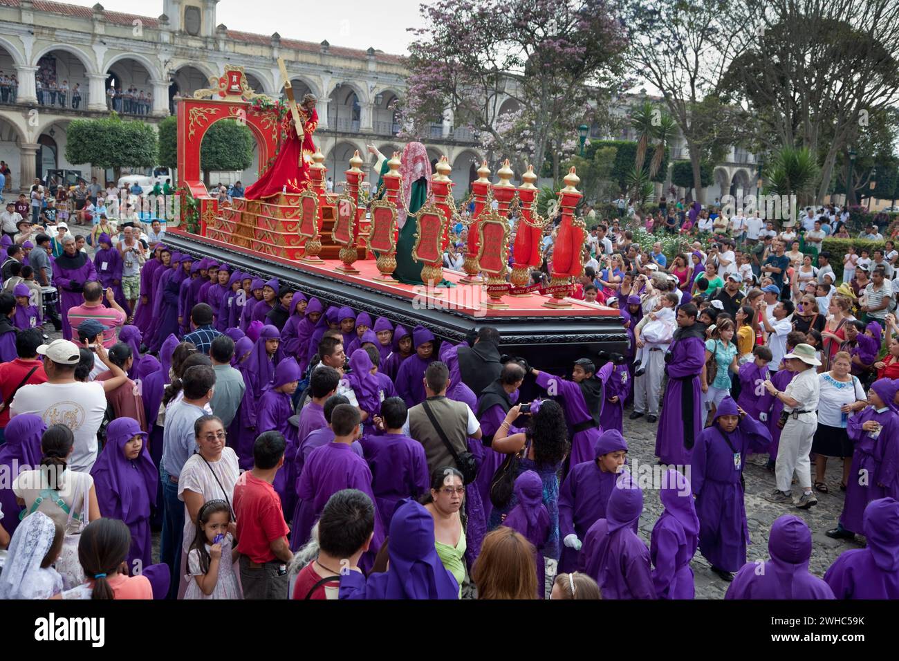 Antigua, Guatemala. Spectateurs, famille et touristes observez des adolescents portant un flotteur dans une procession religieuse pendant la semaine Sainte, la Semana San Banque D'Images