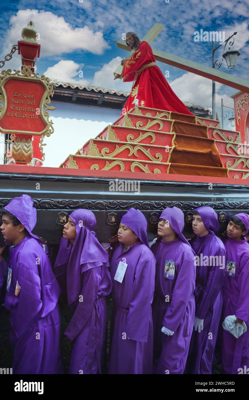 Antigua, Guatemala. Adolescents garçons portant un flotteur dans une procession religieuse pendant la semaine Sainte, la Semana Santa. Banque D'Images