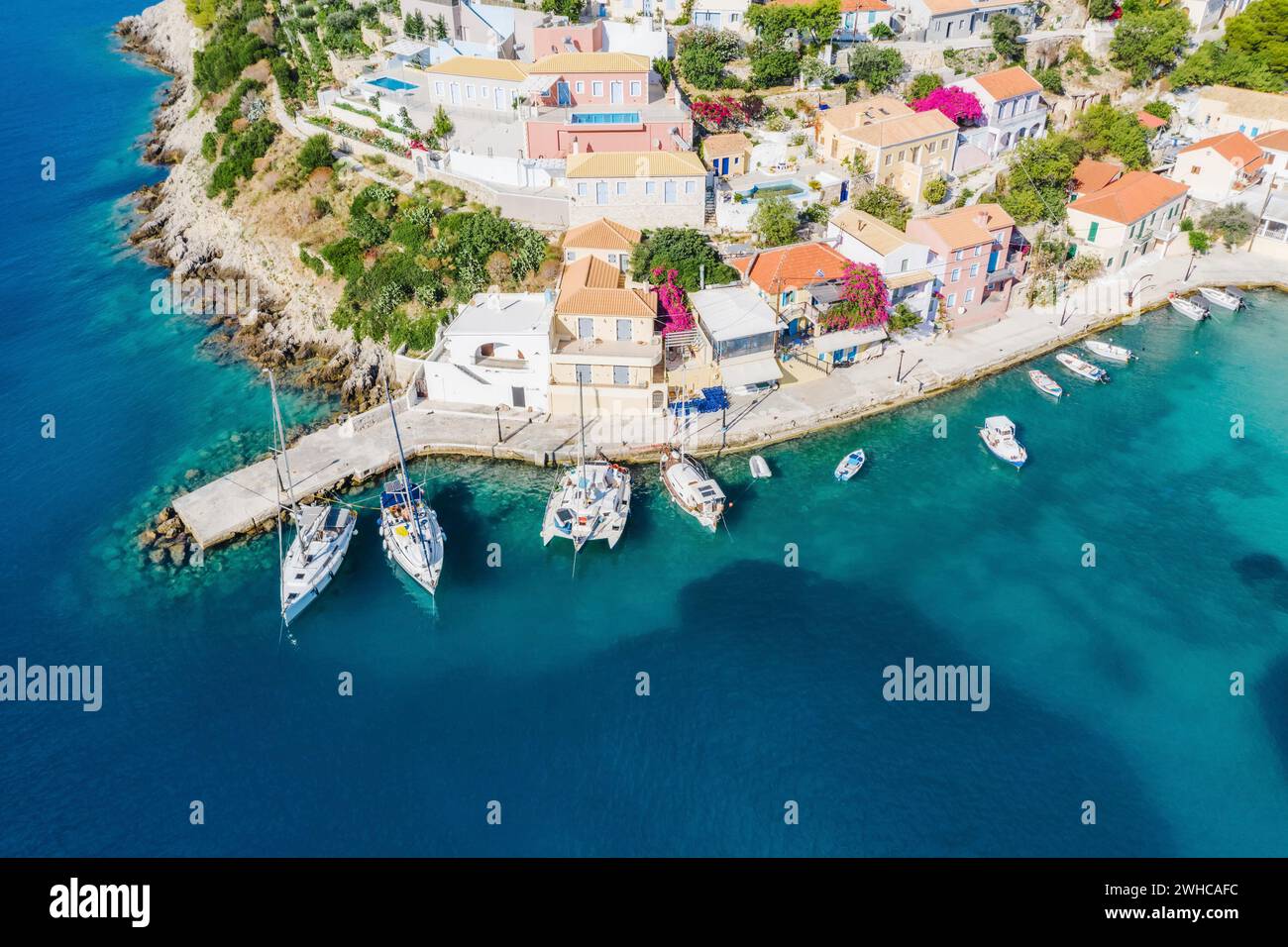 Assos pittoresque village de pêcheurs d'en haut, Kefalonia, Grèce.Vue aérienne de drone.Bateaux à voile amarrés dans la baie turquoise. Banque D'Images