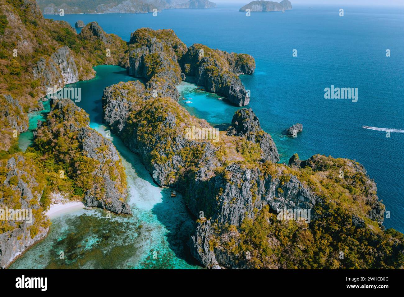 Drone aérien sur le magnifique paysage du blue lagoon tropical entouré de falaises calcaires déchiquetées. Docks de Miniloc Island, El Nido, Palawan, Philippines. Banque D'Images