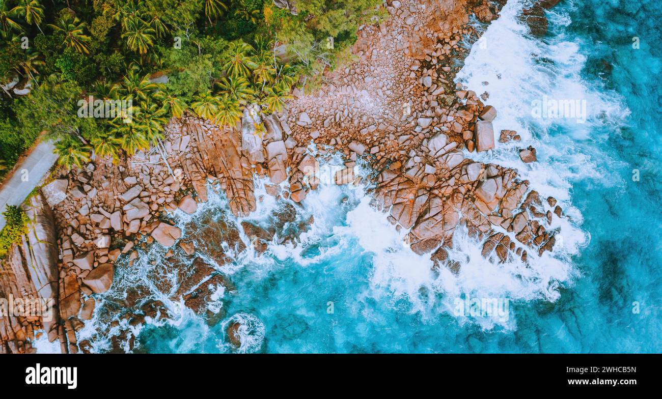 Vue aérienne de drone sur la côte tropicale avec vagues turquoise de l'océan éclaboussant contre des rochers de granit bizarres. Concept de voyage. Banque D'Images