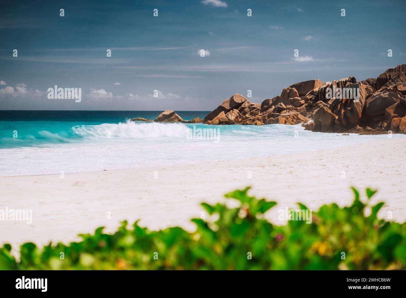 Vagues mousseuses de l'océan et plage de sable blanc à petite Anse, la Digue aux Seychelles. Banque D'Images
