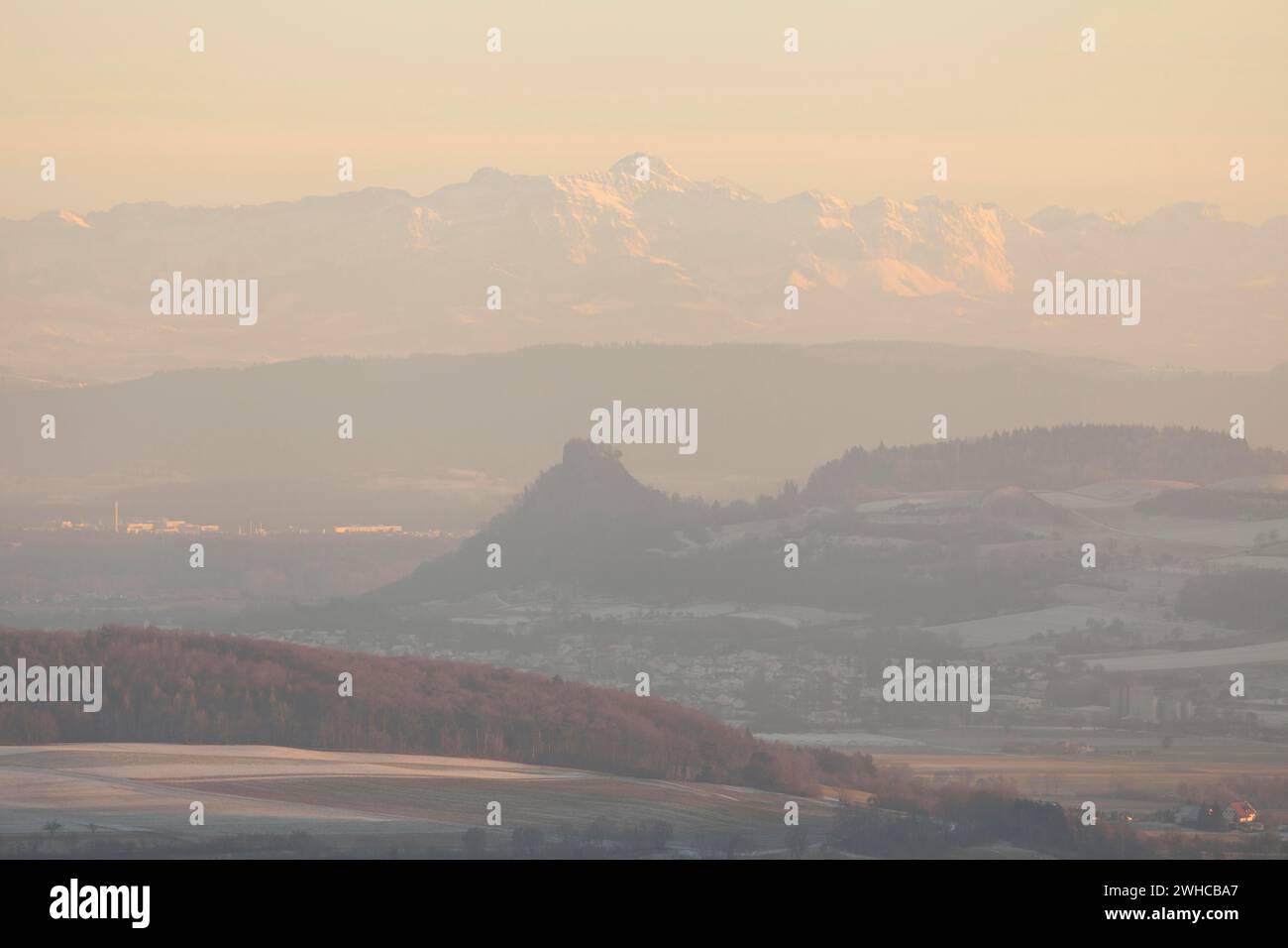 Hegaublick en hiver et au coucher du soleil. Les ruines du château de Hohenkraehen avec les Alpes et les Saentis Banque D'Images