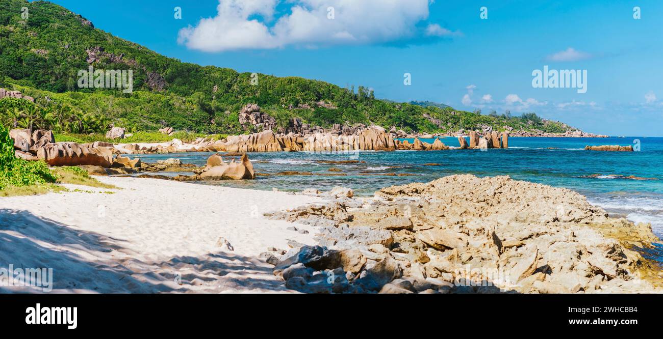 La Digue, Seychelles. Vue panoramique sur la belle plage isolée, la côte tropicale de l'océan, les rochers de granit uniques et la jungle en arrière-plan. Banque D'Images