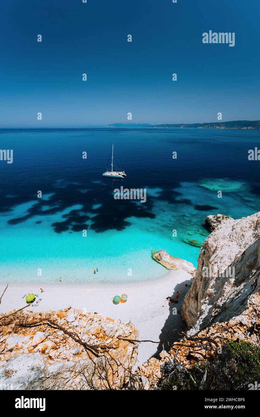 Fteri beach, île de Céphalonie Céphalonie, Grèce. Yacht à voile blanc bleu clair l'eau de mer. Les touristes sur une plage de sable du lagon. Banque D'Images