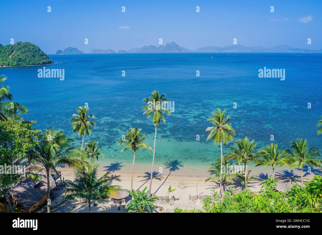 Plage de sable avec Palm Shadows, d'énormes rochers en arrière-plan, El Nido, Palawan, Philippines. Banque D'Images