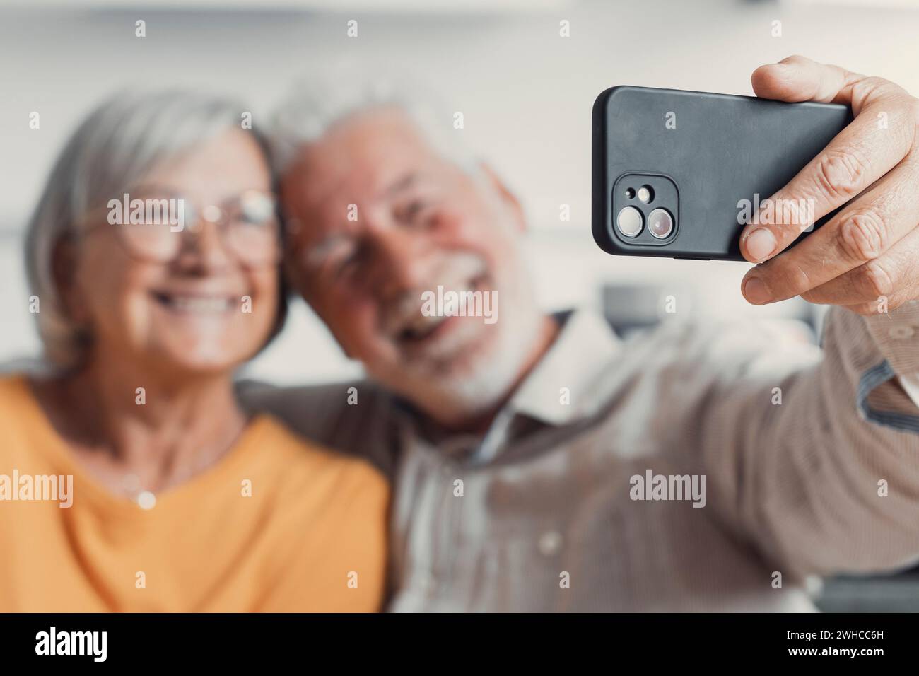 Heureux vieux couple prenant selfie sur téléphone portable, souriant époux matures aînés épouse d'âge moyen et mari retraité riant tenant le téléphone faire l'autoportrait sur l'appareil photo de smartphone, se concentrer sur l'affichage mobile Banque D'Images