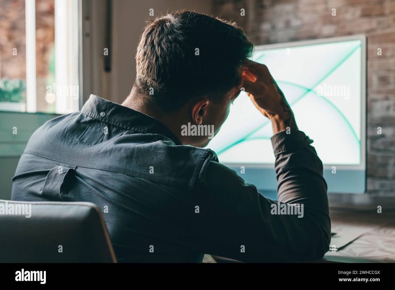 Homme fatigué stressé dans la douleur ayant une forte attaque terrible de mal de tête après le travail d'ordinateur portable, fatigué gars épuisé souffrant de migraine chronique massant tempes pour soulager la tension de mal de tête Banque D'Images