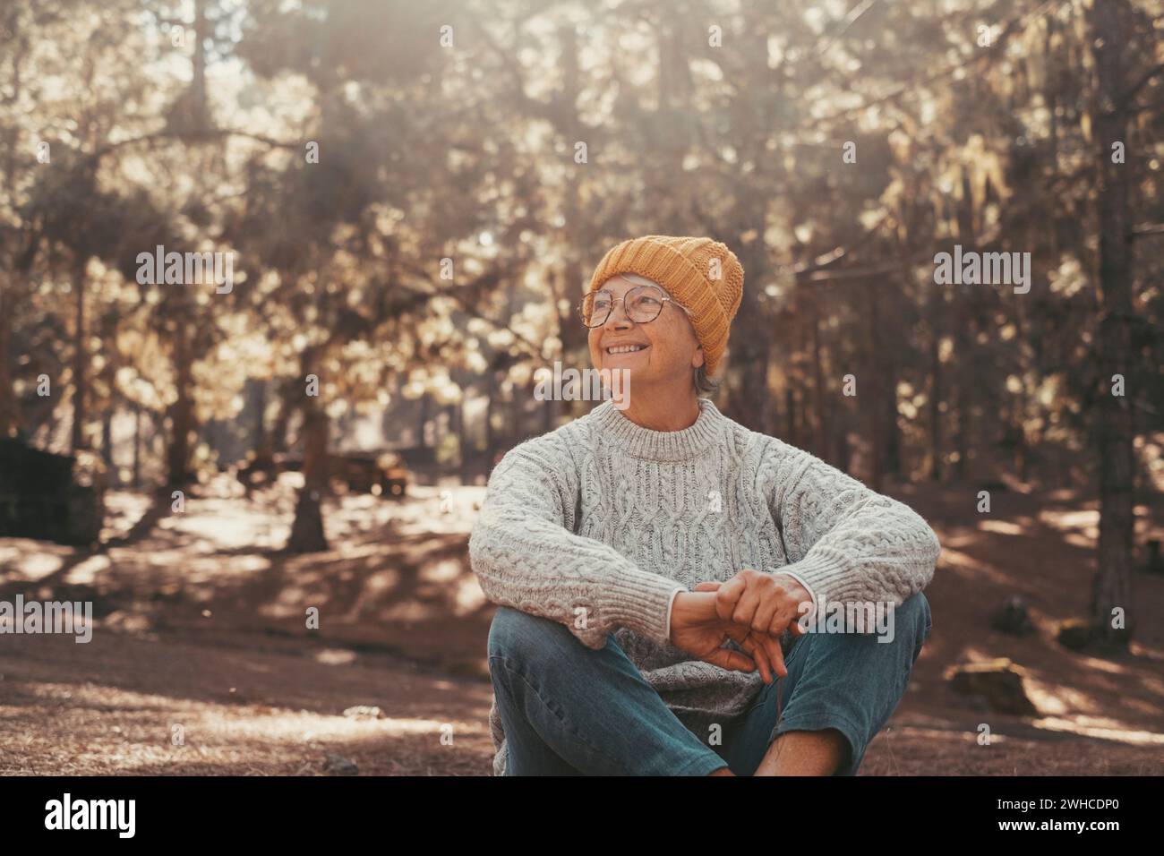 Portrait, gros plan d'une femme âgée d'âge moyen se reposant et se relaxant faisant du yoga dans la forêt de montagne dans la nature. Une personne féminine mature et joyeuse souriante appréciant. Banque D'Images