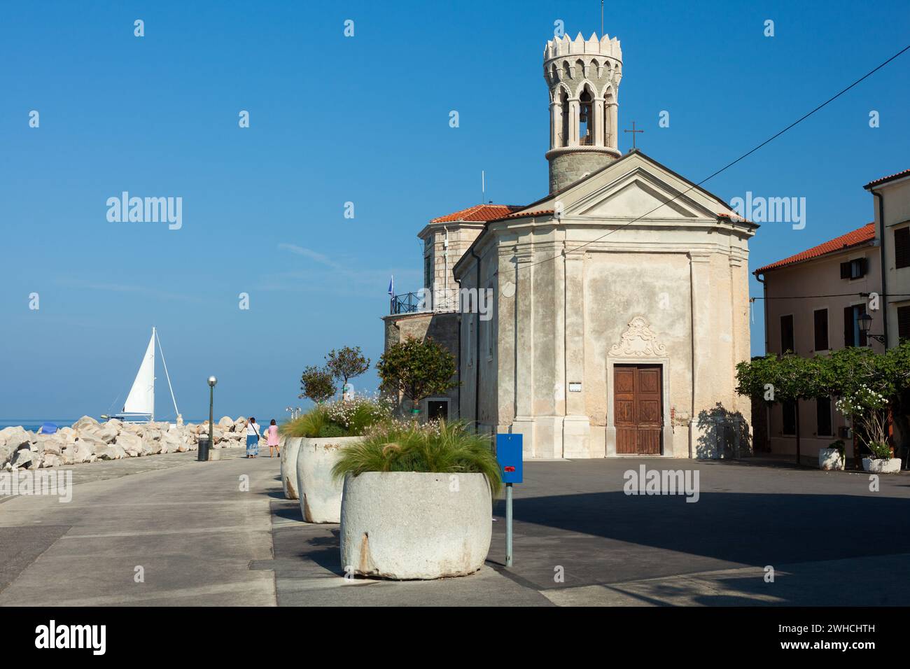 Belle église ancienne de notre-Dame de la santé près de la mer, placée sur la côte Piran de Slovénie. Vieille église de la ville de la pierre en été avec Banque D'Images