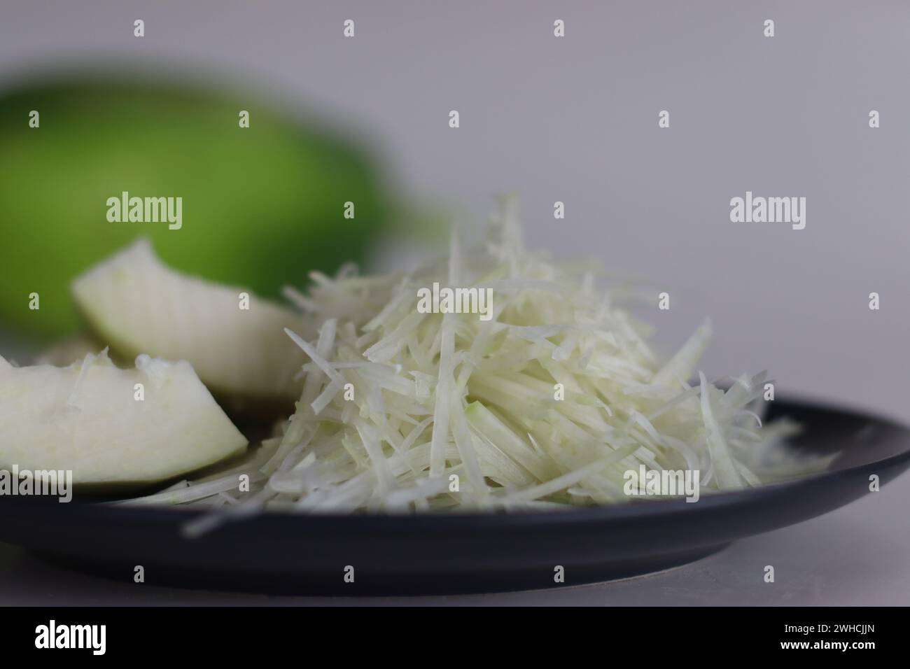 Papaye verte crue fraîche et papaye râpée, parfaites pour des recettes saines et des salades éclatantes. Produits tropicaux riches en nutriments pour les enthusi alimentaires Banque D'Images