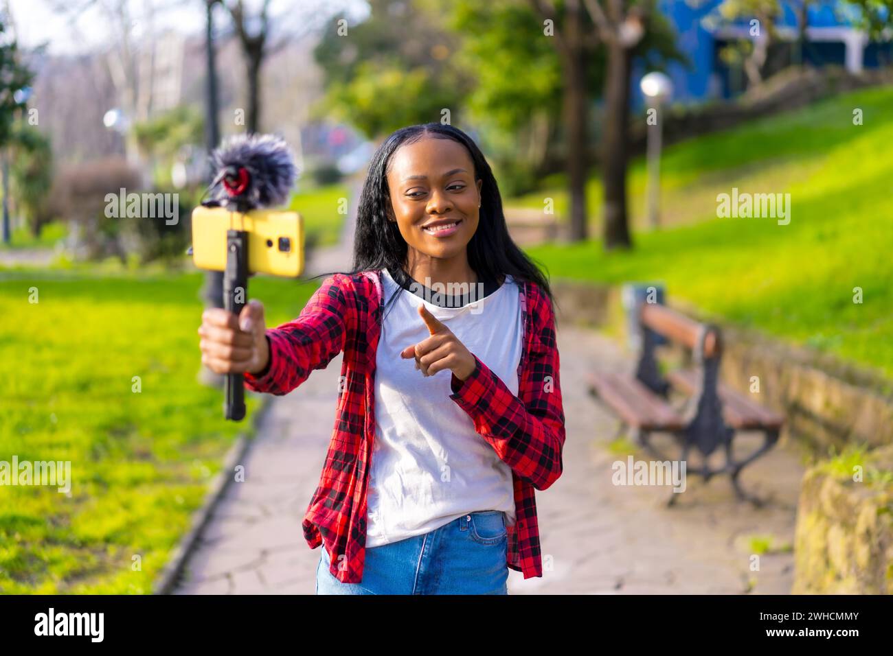 Photo frontale d'une femme africaine vlogging enregistrant une vidéo avec mobile de la ville Banque D'Images