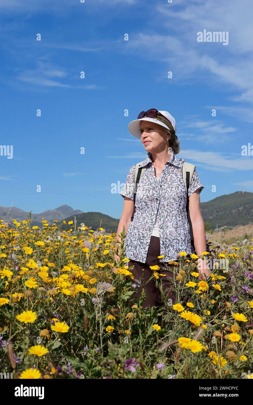 Femme debout dans un pré fleuri, Majorque, Îles Baléares, Espagne Banque D'Images